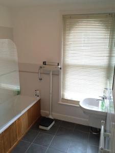 a bathroom with a tub and a sink and a bath tub at 2 Bedroom Boutique Maisonette on Kings Road, St Leonards on Sea in St. Leonards