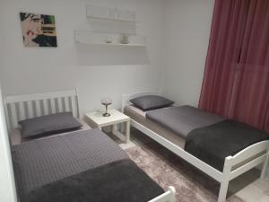 2 camas individuales en una habitación con cortinas rojas en Lux Old Bridge, en Mostar