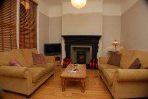 a living room with two couches and a fireplace at 2 Bedroom Boutique Maisonette on Kings Road, St Leonards on Sea in St. Leonards