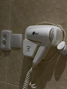 a hair dryer is attached to a wall at Думан Холл Отель in Taraz