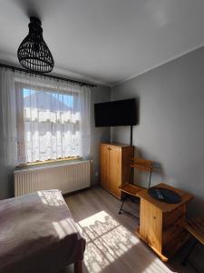 a bedroom with a bed and a flat screen tv at Pokoje gościnne u Izy in Tolkmicko