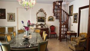 a dining room with a table with a vase of flowers on it at SEA VIEW Apartment in Giardini Naxos