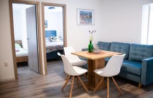 a living room with a table and a blue couch at Amber in the centar in Kaštela