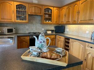 a kitchen with a tray with a croissant and coffee cups at Ty Cerrig in Dyffryn