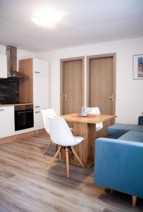 a kitchen and living room with a table and a blue couch at Amber in the centar in Kaštela