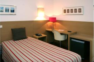 a bedroom with a bed and a desk and a chair at Costa do Sol B&B in Porto