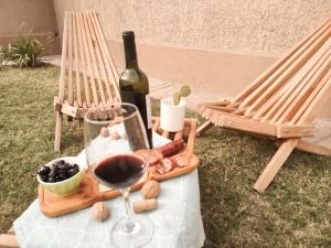 查克拉斯德科里亞的住宿－La Isolina Casa en Chacras de Coria，一张桌子,上面放着一瓶葡萄酒和一杯