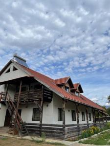 a house with a red roof and a sky at Casa La doi nuci in Brădet