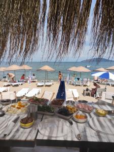 una mesa con platos de comida en la playa en ŞEREF APART MOTEL, en Marmara