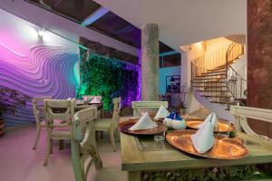 une salle à manger avec une table, des chaises et un escalier dans l'établissement HOSTAL DEL RÍO, à Ibarra
