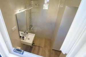 a bathroom with a sink and a mirror at Kumquat studio Gouvia in Gouvia