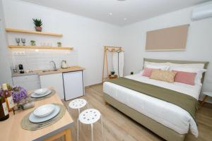 a bedroom with a large bed and a kitchen at Kumquat studio Gouvia in Gouvia