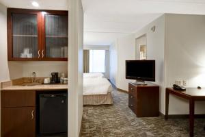 a hotel room with a kitchen and a bedroom at SpringHill Suites Louisville Airport in Louisville