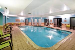 a pool in a hotel room with tables and chairs at SpringHill Suites Louisville Airport in Louisville
