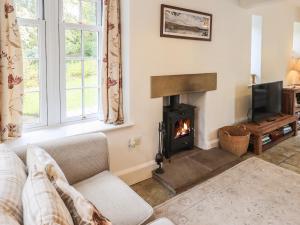 a living room with a fireplace and a couch at The Old Post House at Low Stott Park in Ulverston