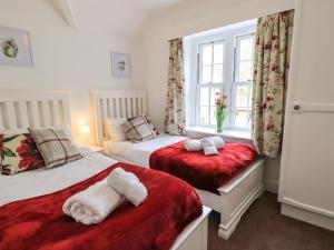 a bedroom with two beds and a window at The Old Post House at Low Stott Park in Ulverston