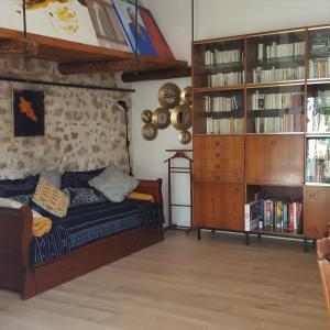 uma sala de estar com uma cama e uma estante de livros em Little house with a large roof garden in the city center em Marselha