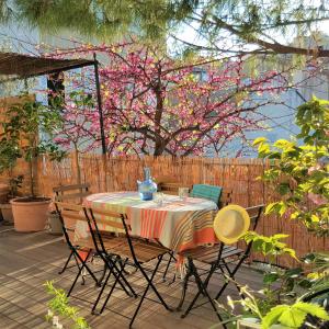 a table and chairs on a patio with a flowering tree at Little house with a large roof garden in the city center in Marseille