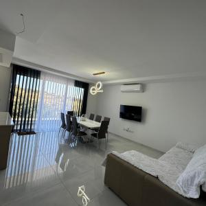 a living room with a couch and a table and chairs at ONE100 apartments in Marsaxlokk