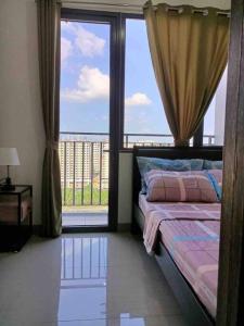 a bedroom with a bed and a large window at Shore 2 Staycation - Near Mall of Asia and Casinos in Manila