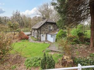 an old stone house in the middle of a garden at North Lodge in Grasmere