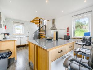 a kitchen with a counter and some chairs in it at Ben Ma Cree in Portpatrick