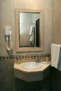 a bathroom with a sink and a mirror at Costa do Sol B&B in Porto