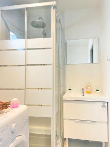 y baño con ducha, lavabo y lavadora. en Duplex 2 Chambres - Secteur CHU de Rouen - Capacité 6 Personnes- WIFI, en Rouen