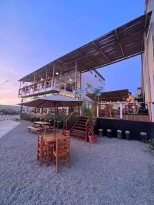 - un bâtiment avec une table, des chaises et un parasol dans l'établissement Casablanca del Mar, à Punta Hermosa