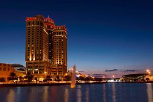 a city with two tall buildings in the water at night at Sheraton Mall of the Emirates Hotel, Dubai in Dubai