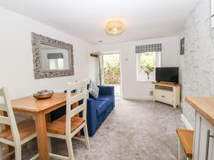 uma sala de estar com um sofá azul e uma mesa em Hideaway Cottage em Barnoldswick