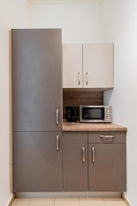uma cozinha com armários de aço inoxidável e um micro-ondas em My city apartment-Vienna Familyroom em Viena
