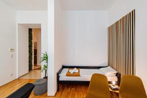 um quarto com uma cama e duas cadeiras em My city apartment-Vienna Familyroom em Viena