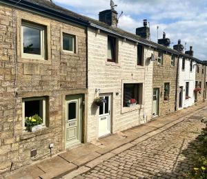 a row of stone houses on a cobblestone street at Hideaway Cottage in Barnoldswick +13 photos