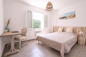 a bedroom with a bed and a table and a chair at Petit Paradis Garrigue in Moulézan
