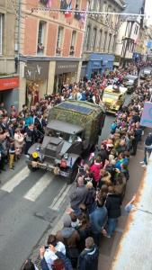 a crowd of people watching an old military truck at Authentique studio au cœur de Bayeux in Bayeux