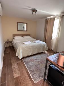 a bedroom with a bed and a table and a television at Madonna Guest House in Dubrovnik