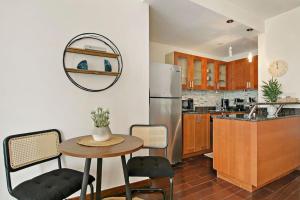 a kitchen with a table and a refrigerator at Stylish Studio with Full Kitchen & Modern Bathroom - Chestnut 15C in Chicago