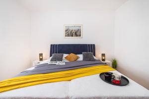 a bedroom with a bed with a yellow and blue blanket at Apartment Marija in Novigrad Dalmatia