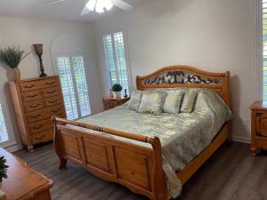 Schlafzimmer mit einem Bett, einer Kommode und Fenstern in der Unterkunft Country Villa pool hot tub game room pond in Jacksonville