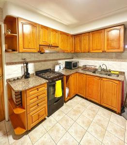 a kitchen with wooden cabinets and a stove top oven at Paramont Tucuman in San Miguel de Tucumán