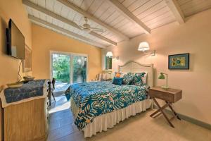 een slaapkamer met een bed en een televisie en een tafel bij 4BR Private Beach Access Upscale Cottage with Grill and Paddle Boards in Englewood