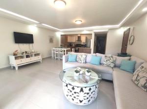 uma sala de estar com um sofá e uma mesa em Chic Beach Apartment - 3 min to the Beach em Punta Cana