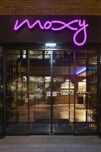 a neon sign on the front of a store at Moxy York in York