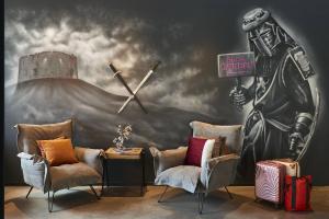 a room with two chairs and a clock on a wall at Moxy York in York