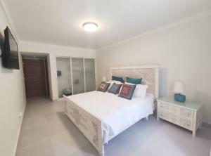 um quarto com uma cama grande e uma mesa de cabeceira em Chic Beach Apartment - 3 min to the Beach em Punta Cana