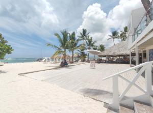 uma praia de areia com palmeiras e um edifício em Chic Beach Apartment - 3 min to the Beach em Punta Cana