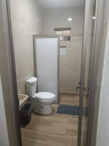 La salle de bains est pourvue de toilettes et d'une cabine de douche. dans l'établissement Hotel Romo, à Los Mochis