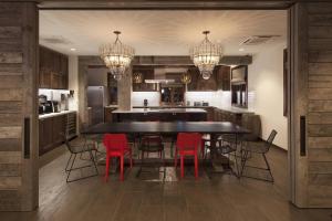 una cucina con un grande tavolo nero e sedie rosse di Moxy Santa Barbara a Santa Barbara