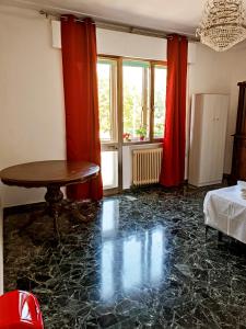 salon ze stołem i czerwonymi zasłonami w obiekcie Locazione Turistica w mieście Tessera